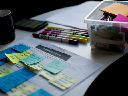 An image of sticky notes, pens and a box of stationary